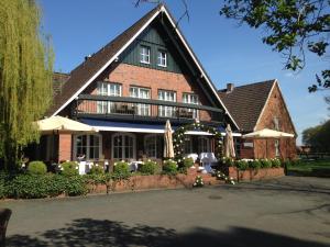 ein großes Backsteingebäude mit Sonnenschirmen davor in der Unterkunft Waldhaus an de Miälkwellen in Ladbergen