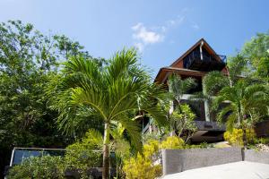 a house with palm trees in front of it at Thara Bayview Villa, SHA Certified in Ao Nang Beach