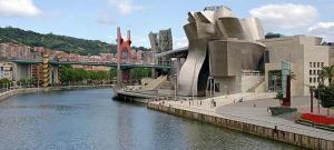 a building next to a river with a bridge at Jan&Joan Apartment in Bilbao