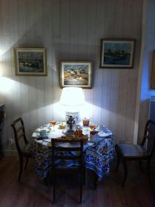 uma mesa de jantar com um candeeiro e 2 cadeiras em Le Châtel em Riec-sur-Bélon