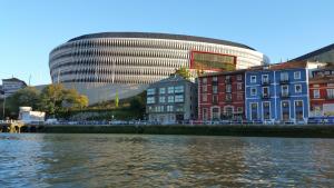 a group of buildings next to a river with a building at Jan&Joan Apartment in Bilbao