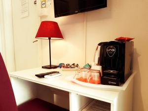 un tavolo con una macchinetta del caffè e una lampada sopra di Oberdan a Catania