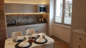 a kitchen with a table with plates and glasses on it at Studio Centrum Ratusz in Częstochowa