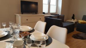 a dining room with a table with white plates and wine glasses at Studio Centrum Ratusz in Częstochowa