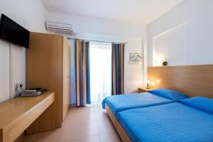 a bedroom with a blue bed and a window at Corafili Holiday Suites in Kiotari