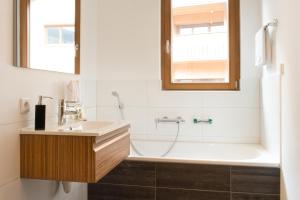 a bathroom with a sink and a bath tub at Verwall Apartment in Schruns-Tschagguns +2 photos