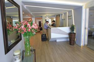 a lobby with a counter with pink flowers in a vase at Samana Hotel in Arequipa