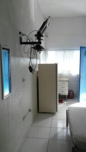 a room with a refrigerator and a camera on the wall at Apartamentos Águia Suíte casal 2 in Ilha Comprida