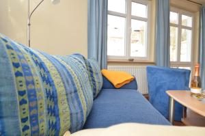 um sofá azul com uma almofada amarela e uma mesa em Villa Seerose - Appartement 03 em Ostseebad Sellin