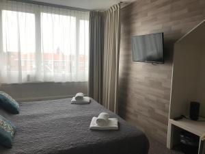 ein Hotelzimmer mit einem Bett mit Handtüchern darauf in der Unterkunft Hotel Valkenhof in Zoutelande