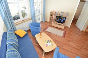uma sala de estar com um sofá azul e uma mesa em Villa Seerose - Appartement 03 em Ostseebad Sellin