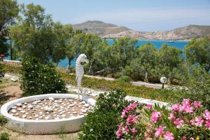 a statue of a bird in a garden with flowers at Hippocampus Hotel in Naousa
