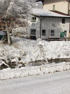 フラッハウにあるMaisonette Haus Amadeの雪に覆われた通りの隣の建物