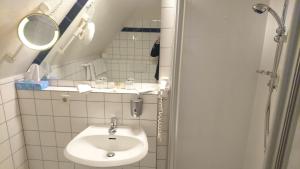 ein kleines Badezimmer mit Waschbecken und Spiegel in der Unterkunft Waldhaus an de Miälkwellen in Ladbergen + 22 Fotos