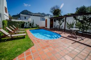 a swimming pool in the backyard of a house at Noordhoek Village Hotel in Noordhoek