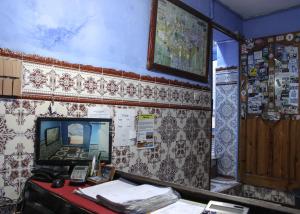 una camera con scrivania e TV appesa a un muro di Hotel Souika a Chefchaouen