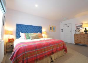 a bedroom with a large bed with a blue headboard at The Narrowboat in Reading