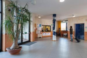 a man standing in a lobby with a plant at La Cordata Accommodation - Zumbini 6 in Milan