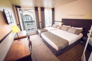 a hotel room with a bed and a large window at Timhotel Paris du Gare du Nord in Paris