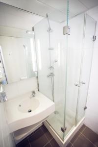a bathroom with a sink and a glass shower at Timhotel Paris du Gare du Nord in Paris