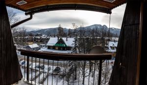 ザコパネにあるGoralska Tradycjaの雪に覆われた町の景色を望むバルコニー