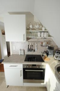 een keuken met witte kasten en een fornuis met oven bij Exklusiv Wohnung Nika in Westerland