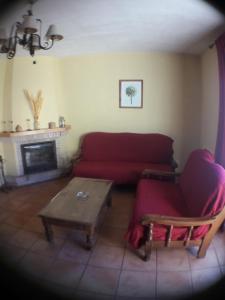 Sala de estar con sofá rojo y mesa de centro en Parque Sierra Norte, en Rascafría