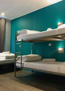 パリにあるプラグ イン モンマルトル バイ ヒップホップホステルズの青い壁のドミトリールームの二段ベッド2台分です。