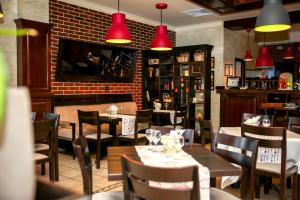 a restaurant with tables and chairs and red lights at Pensiunea Casa Vera in Târgu Jiu