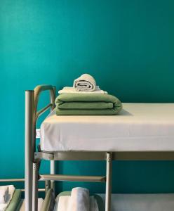 a stack of towels sitting on a hospital bed at Plug inn Montmartre by Hiphophostels in Paris