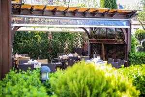 a restaurant with tables and chairs under a pergola at Pensiunea Casa Vera in Târgu Jiu