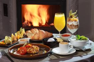 a table with food and drinks and a fireplace at Boutique Hotel Villa Perlov in Saint Petersburg