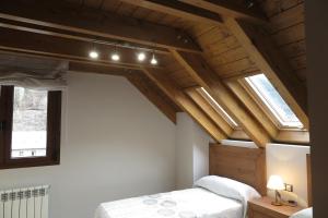 um quarto com uma cama e duas janelas em Casa Bielsa em Bielsa