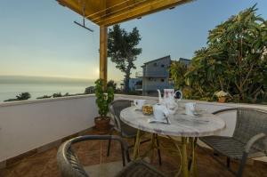 a table and chairs on a balcony with a view of the ocean at Apartments Bluesun in Omiš