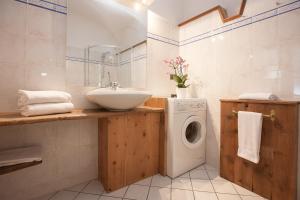 een badkamer met een wastafel en een wasmachine bij Casa Melide 3 in Bormio