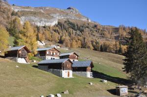 een groep gebouwen op een heuvel met schapen bij Le Mayen de Colombire in Crans-Montana