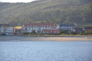 a group of houses on a beach next to the water at Beatiful holiday flat in Galicia with sea views and next to the "Camino de Santiago" in Estorde