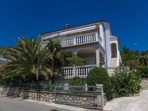 a white house with a palm tree in front of it at Apartment Villa Zdenka in Crikvenica