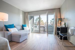 ein Wohnzimmer mit einem Sofa und einem Tisch in der Unterkunft Cascais-Estoril BEACHFRONT Apartments in Estoril