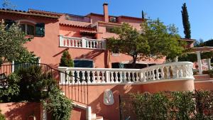 un grand bâtiment rose avec un balcon blanc dans l'établissement La Florentine, à Bandol