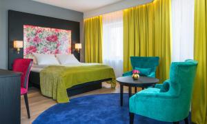 a hotel room with a bed and colorful chairs at Thon Hotel Arendal in Arendal +37 photos