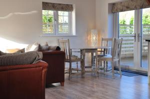 a living room with a couch and a table and chairs at Rosebank Barn in Brentor