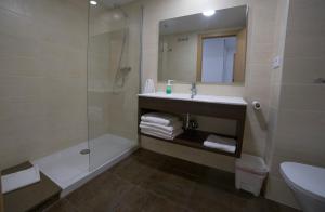 uma casa de banho com um lavatório, um chuveiro e um WC. em Apartaments Ponent em Lloret de Mar