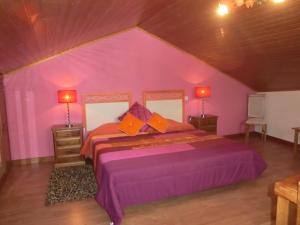 a pink bedroom with a large bed and two lamps at Solar de Rabal in Bragança