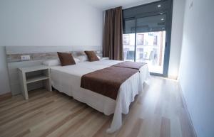 - une chambre avec un lit et une grande fenêtre dans l'établissement Apartaments Ponent, à Lloret de Mar