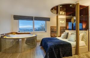 1 dormitorio con bañera, 1 cama, 1 cama y 1 cama doble en June street Spa apartments, en Vilna