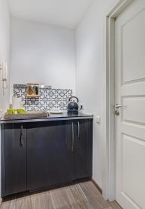 una cucina con piano di lavoro nero in una camera di June street Spa apartments a Vilnius