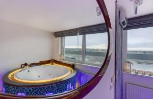 Cette chambre dispose d'une grande baignoire et d'une fenêtre. dans l'établissement June street Spa apartments, à Vilnius