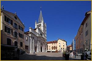 a church with a steeple in the middle of a street at Le Cocon De Notre Dame in Annecy