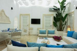 a living room with blue and white furniture and a table at Dar Indigo in Sidi Bou Saïd